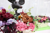 ネズミの人形が花を抱えている写真