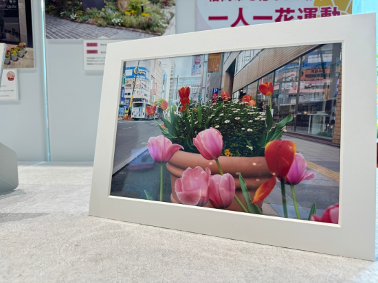白い額縁に入った写真が一枚飾られている。写真には博多駅前の通り沿いに、赤やピンクのチューリップが咲いている様子が写っている。